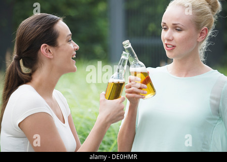Le donne di bere insieme, il tintinnio delle bottiglie Foto Stock