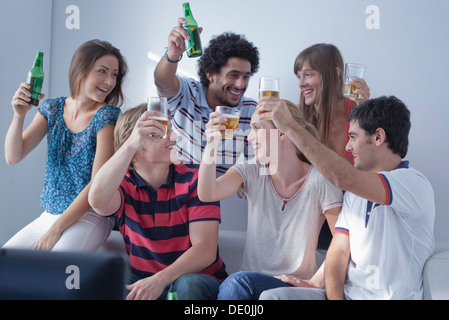 Amici guardare sport match in televisione insieme celebrare del team Vittoria Foto Stock