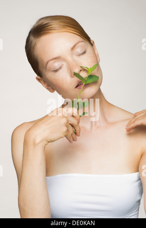 Giovane donna godendo fragrence di foglie di menta fresca Foto Stock