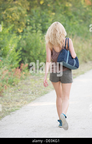 Giovane donna in movimento, vista posteriore Foto Stock