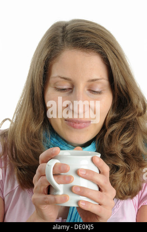 Giovane donna gustando una tazza di caffè Foto Stock