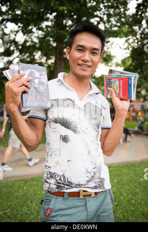 Pagaiando prenota venditore nel lago Hoan Kiem lato, Hanoi, Vietnam Foto Stock