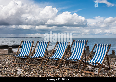 Blu e Bianca a strisce di sedie a sdraio sulla spiaggia, whitstable kent, Regno Unito. Foto Stock