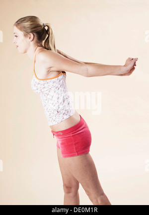 Giovane donna facendo esercizi di stretching Foto Stock