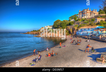 La gente sulla spiaggia di Brixham Devon England su un cielo blu giorno in HDR Foto Stock