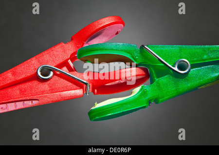 Un rosso vestiti-PEG e un verde vestiti-peg sono in lotta tra di loro, immagine simbolica per il potere politico lotte Foto Stock