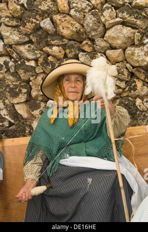 Donna anziana la filatura della lana presso la Santa Eulalia annualmente tradizionale fiera di artigianato, Santa Eulalia, Ibiza, Spagna, Europa Foto Stock