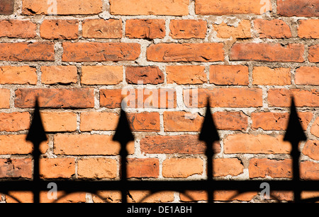 In mattoni rossi e parete nero ferro battuto recinzione Foto Stock