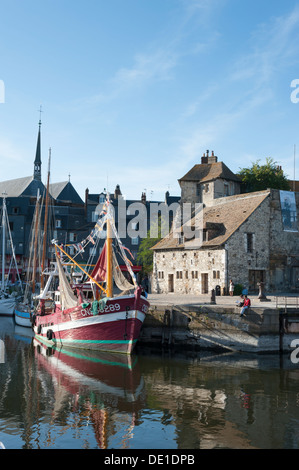 Il porto e il porto di Honfleur Normandia Francia con barche da pesca ormeggiate e vecchi edifici sul quay. Foto Stock