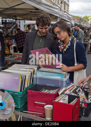 Coppia giovane guardando a dischi in vinile in una fase di stallo in una strada del mercato di Londra, Regno Unito Foto Stock