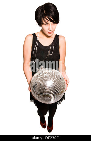 Giovane donna con una palla da discoteca nelle sue mani Foto Stock