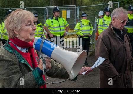 Balcombe, West Sussex. Decimo Sep, 2013. Vanessa Underwood legge un toccante Cuadrilla anti fracking poesia al di fuori del sito ingresso sorvegliato dalla polizia. Charles Metcalfe ascolta lo Stato d'animo cupo. Il anti fracking ambientalisti stanno protestando contro forature di prova da Cuadrilla sul sito in West Sussex che potrebbe portare al controverso processo fracking. Credito: David Burr/Alamy Live News Foto Stock