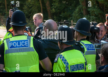 Balcombe, West Sussex. Decimo Sep, 2013. Simon Welsh viene portato via dalla polizia dopo il suo arresto, gridando "Io sono stato arrestato per cantare". Il anti fracking ambientalisti stanno protestando contro forature di prova da Cuadrilla sul sito in West Sussex che potrebbe portare al controverso processo fracking. Credito: David Burr/Alamy Live News Foto Stock