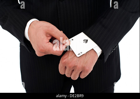 L uomo indossa una tuta tirando un asso di picche al di fuori della sua manica Foto Stock