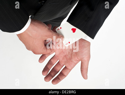 L uomo indossa una tuta tirando un asso di cuori al di fuori della sua manica Foto Stock