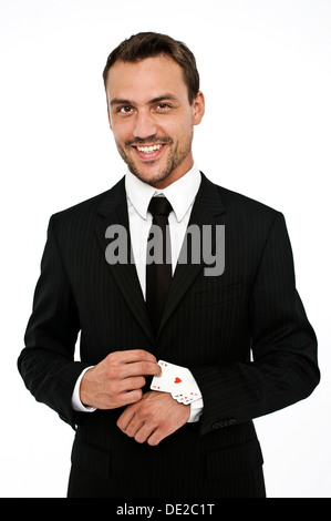 Uomo sorridente indossa una tuta tirando diverse aces al di fuori della sua manica Foto Stock