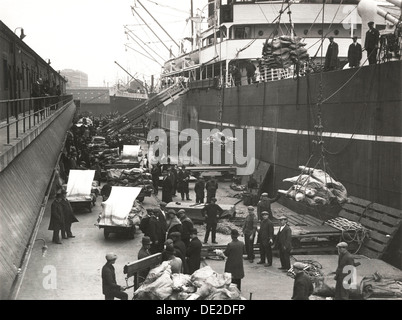 Carico che viene caricato o scaricato da una nave, Royal Victoria Dock, Canning Town, Londra, c1930. Artista: sconosciuto Foto Stock