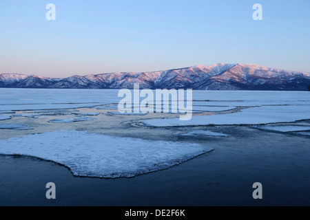 La mattina presto umore sul lago ghiacciato di Kussharo con ice floes nella parte anteriore, Akan-Nationalpark, Kawayu Onsen, Hokkaido, Giappone Foto Stock