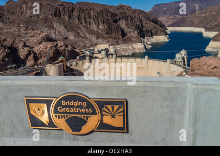 Vista della targa di bronzo che commemora la Diga di Hoover ponte con la Diga di Hoover in background sul Nevada/Arizona confine. Foto Stock