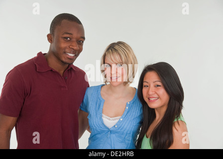 2 giovani donne e un uomo giovane, di carnagione scura uomo donna europea, donna asiatica Foto Stock