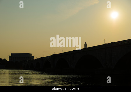 Il sole sorge sopra il Memorial Bridge, visto di Arlington, VA, laterale in quanto copre il Potomac. Il Lincoln Memorial si stagliano sul lato più lontano sul lato sinistro del telaio. Foto Stock