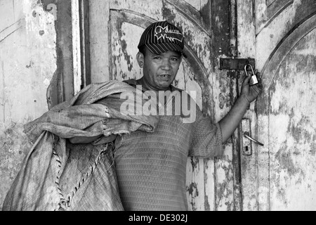 Indonesiano locale uomo in piedi davanti alla porta di una casa abbandonata in kediri java indonesia Foto Stock