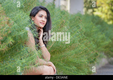 Giovane donna seduta al di fuori Foto Stock