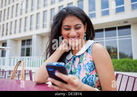 Felice giovane donna guardando smart phone Foto Stock