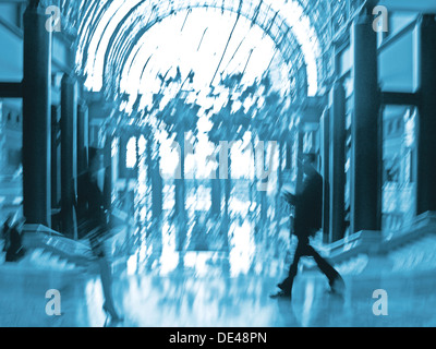 Immagine astratta di un business la gente camminare nella lobby intenzionale di sfocatura di movimento e una tonalità di blu Foto Stock