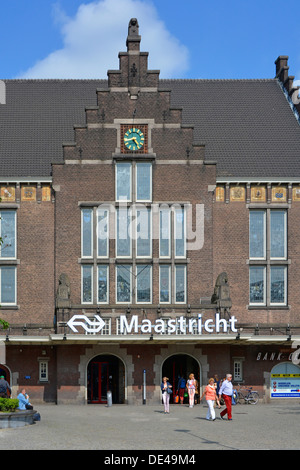 Stazione ferroviaria della città di Maastricht edificio in mattoni e orologio persone fuori dall'ingresso principale e cartello con il logo del marchio Summer in Limburg Paesi Bassi Europa e UE Foto Stock