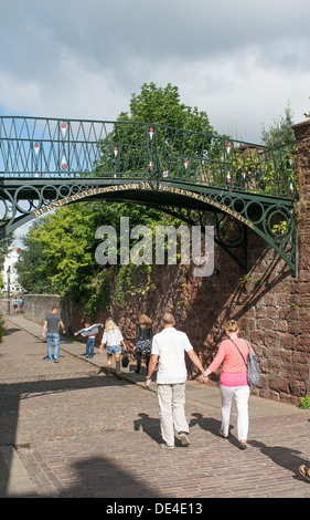 Giovane camminare sotto la storica del ferro battuto Burnett Bridge Patch Exeter Devon, Inghilterra, Regno Unito Foto Stock