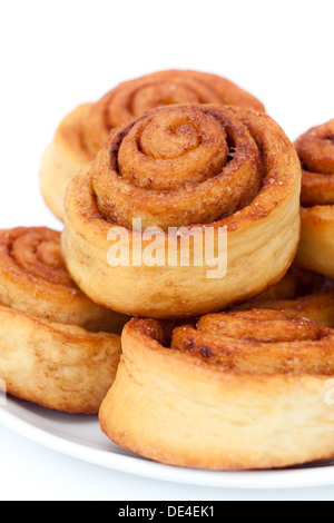 Panini alla cannella gruppo sulla piastra, sfondo bianco Foto Stock