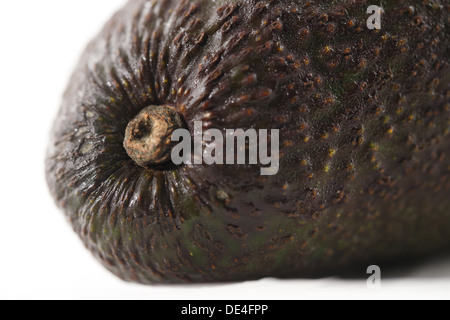 Un organico fresco avocado shot in un creative astratto contro uno sfondo bianco Foto Stock