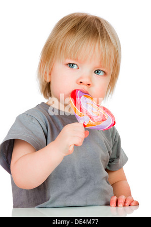 Baby mangiando un appiccicoso lollipop isolati su sfondo bianco. Foto Stock