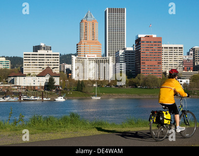 Un ciclista sulla pista ciclabile che corre lungo la sponda orientale del fiume Willamette a Portland, Oregon. Foto Stock