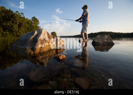 Un uomo getta la sua linea mentre la pesca sul lago di Windsor in Bella Vista, Arkansas.