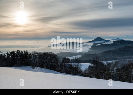 Inverno a Hegau con il coni vulcanici di Hohenhewen, sinistra e Hohenstoffeln, destra, con le Alpi svizzere all'orizzonte Foto Stock