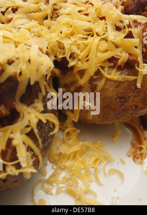 Formaggio grattugiato, quorn chili e jacket potato sulla piastra bianca Foto Stock