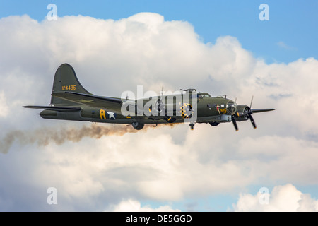 Un Boeing B17 Flying Fortress bombardiere della seconda guerra mondiale in volo, con emissione di fumo dal motore farside. Foto Stock