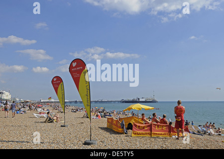 Vista lungo la spiaggia di Brighton con bagnini di pattuglia al Molo di Brighton East Sussex England Foto Stock