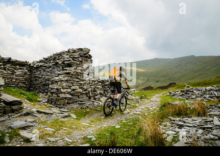 Mountain Biker cavalcando attraverso Walna Scar cave in Coniston Fells nel distretto del Lago Foto Stock