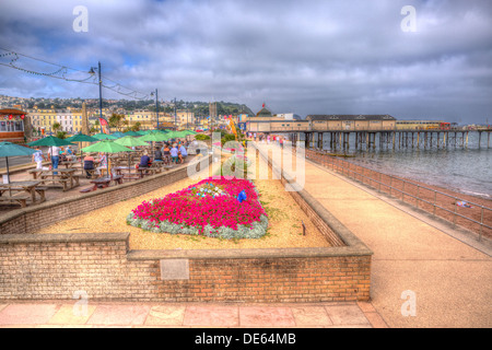 Teignmouth lungomare e pier Devon England, Inglese tradizionale con struttura da mare in HDR con fiori di colore rosso Foto Stock