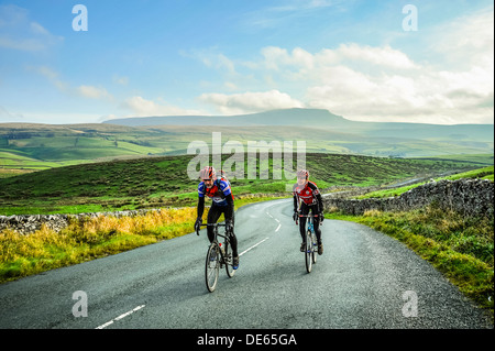 I ciclisti in Ribblesdale nel Yorkshire Dales National Park con Pen-y-Ghent dietro Foto Stock