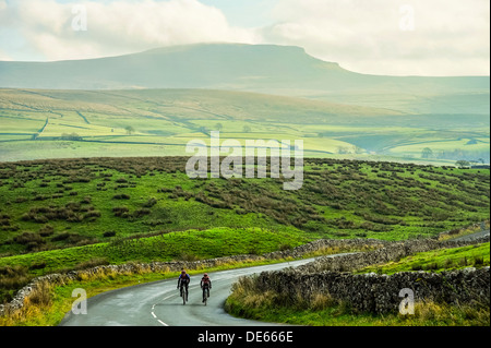 I ciclisti in Ribblesdale nel Yorkshire Dales National Park con Pen-y-Ghent dietro Foto Stock