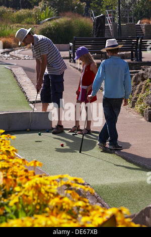 L uomo e i bambini a giocare mini golf a Bournemouth in Settembre Foto Stock