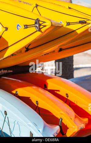 Giallo kayak impilati per stoccaggio presso il centro di noleggio in Cedar Key, Florida Foto Stock