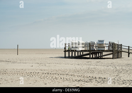 Sankt Peter-Ording, Germania, Strandkoerbe su un molo in legno sulla spiaggia di San Pietro- Ording Foto Stock