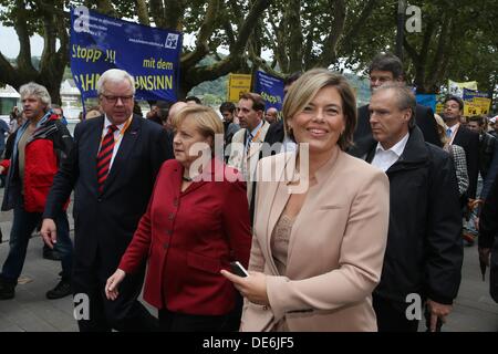 Koblenz, Germania. Xii Sep, 2013. Il cancelliere tedesco Angela Merkel (C) passeggiate passato manifestanti sulla strada di un CDU campagna elettorale caso accompagnato dal vice presidente della CDU gruppo parlamentare Michael Fuchs (L) e CDU membro presidentessa Julia Kloeckner (R) di Coblenza, Germania, 12 settembre 2013. Essi hanno protestato contro il rumore del traffico ferroviario nella valle del medio Reno. Foto: THOMAS FREY/dpa/Alamy Live News Foto Stock