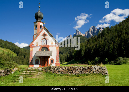 Chiesa di San Giovanni in Ranui nella valle di Villnoss con le Odle montagne sullo sfondo, Dolomiti, Italia. Foto Stock