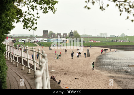 Dangast, Germania, persone corrono in cattive condizioni atmosferiche sulla spiaggia Foto Stock